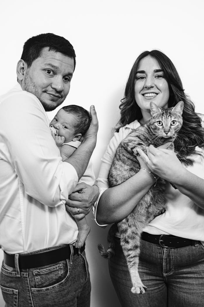 our-story Black and white portrait of a happy family with baby and cat, creating warmth.